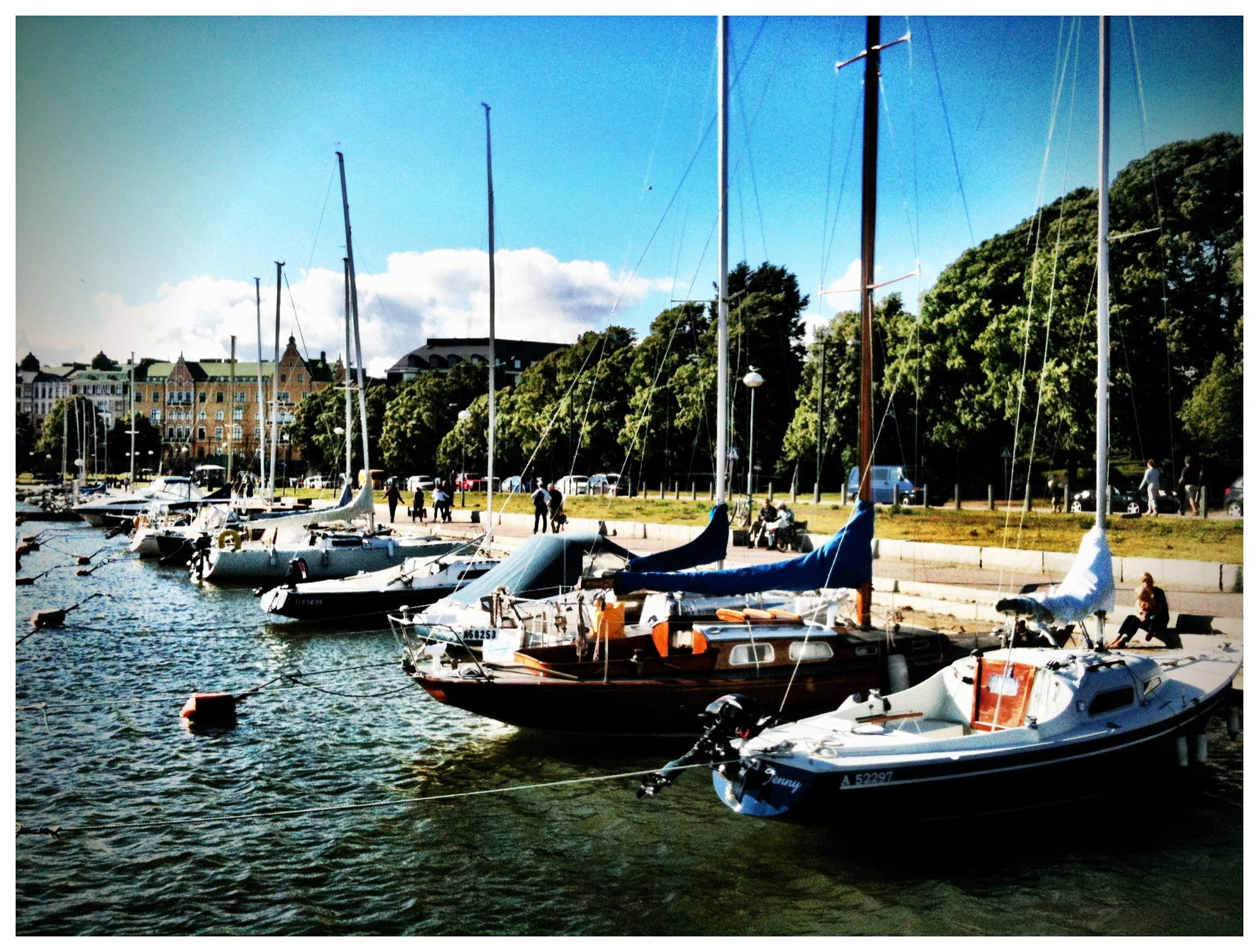 Blick auf die Hafenpromenade in Helsinki mit Segelbooten im Vordergrund