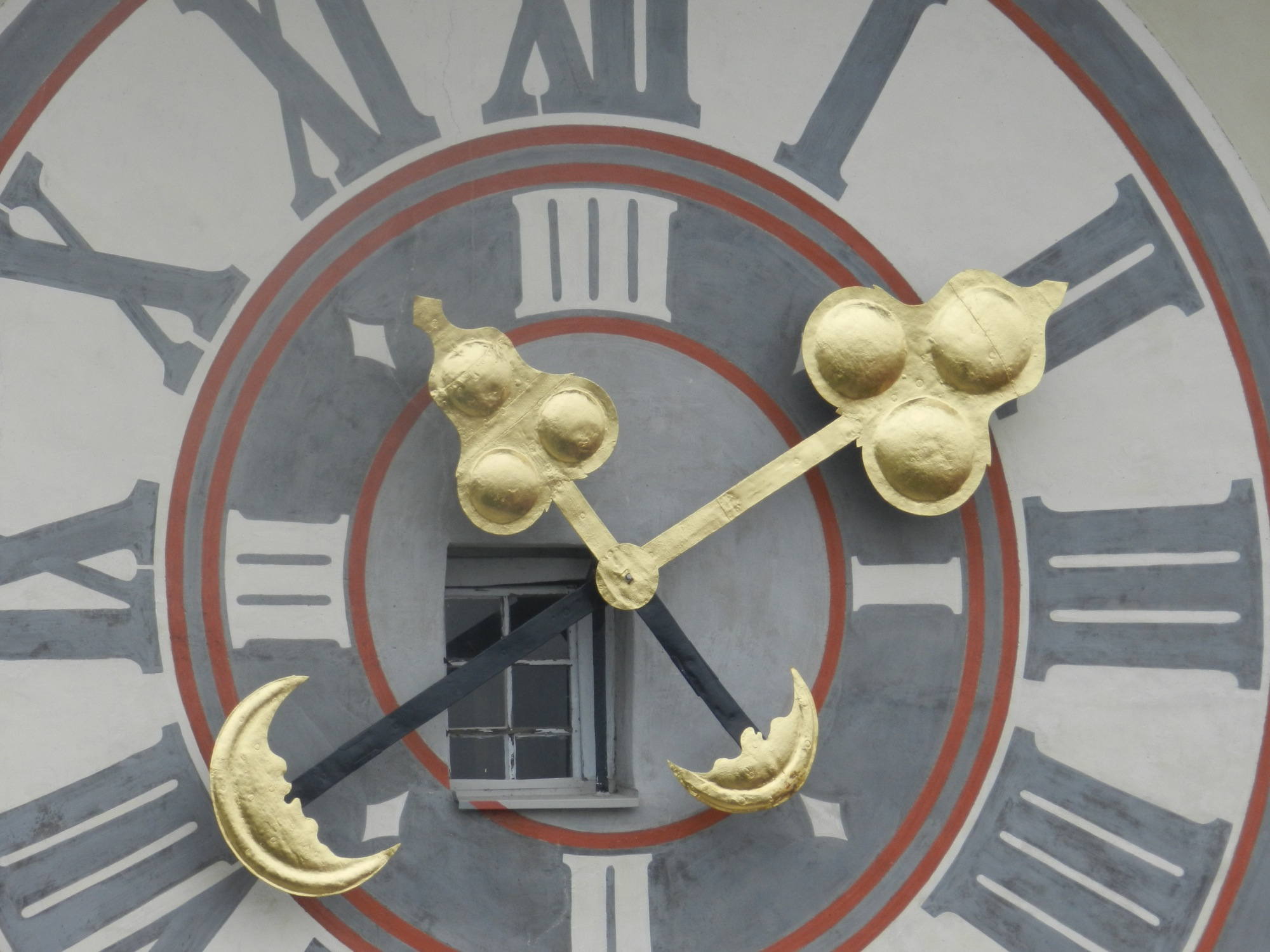 Detailaufnahme der Uhr mit Fenster dahinter am Grazer Uhrturm