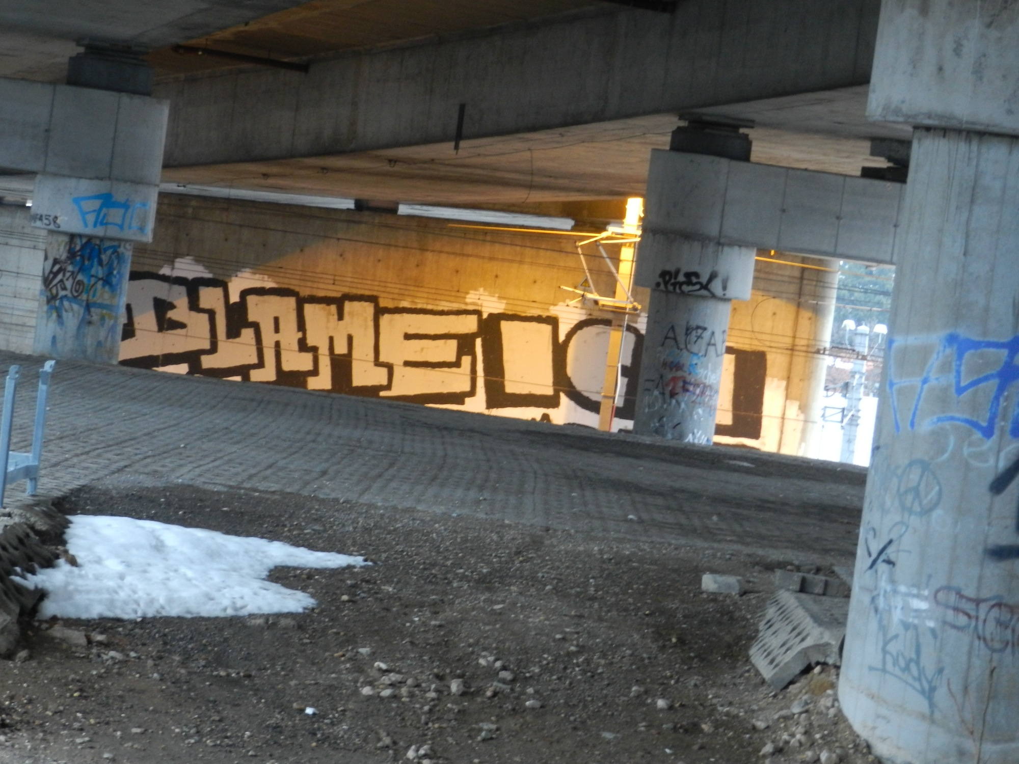 Graffiti unter der Autobahn neben der Bahn