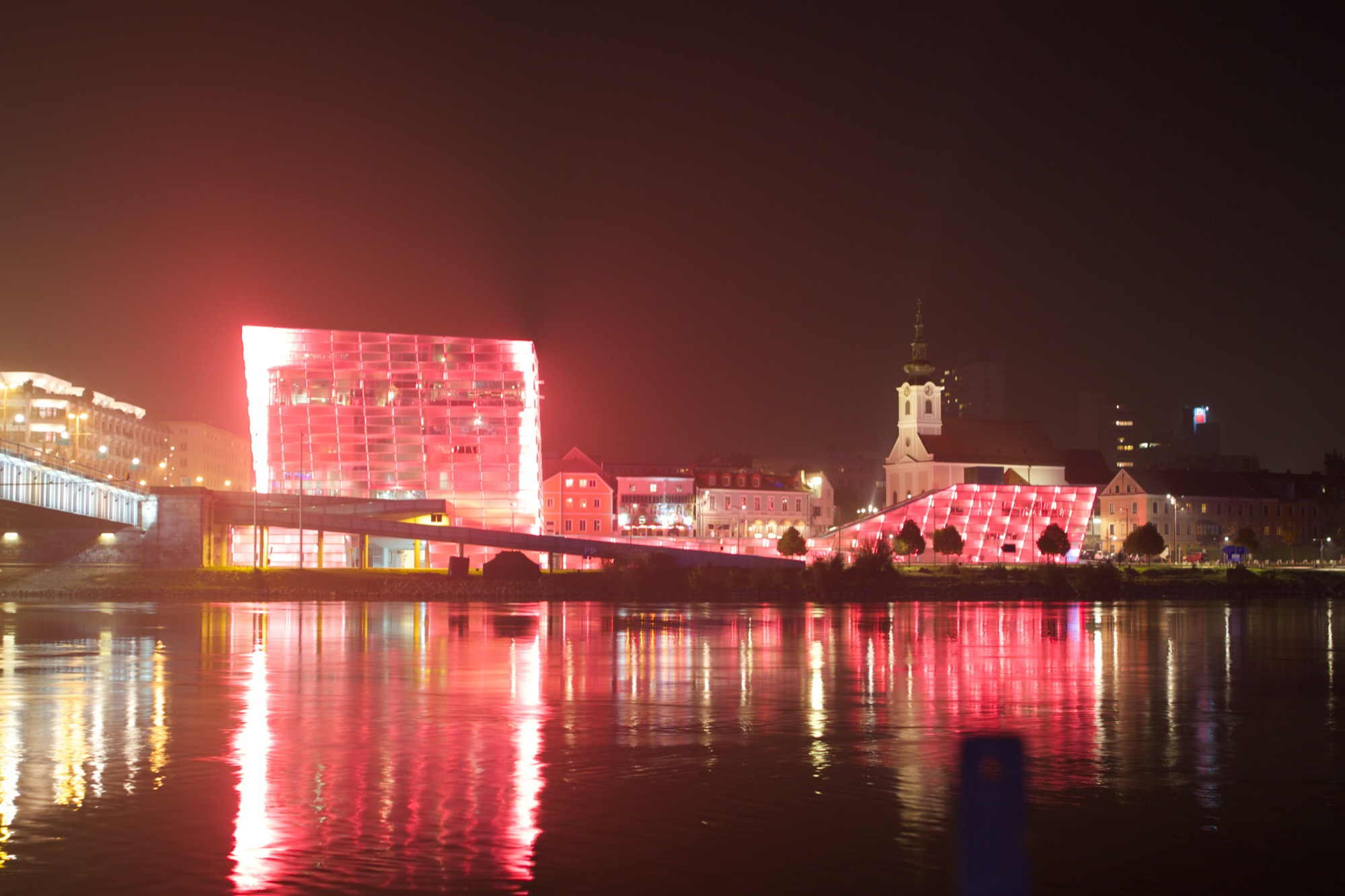 das Ars Electronica Center leuchtet nachts in allen Farben, hier rot