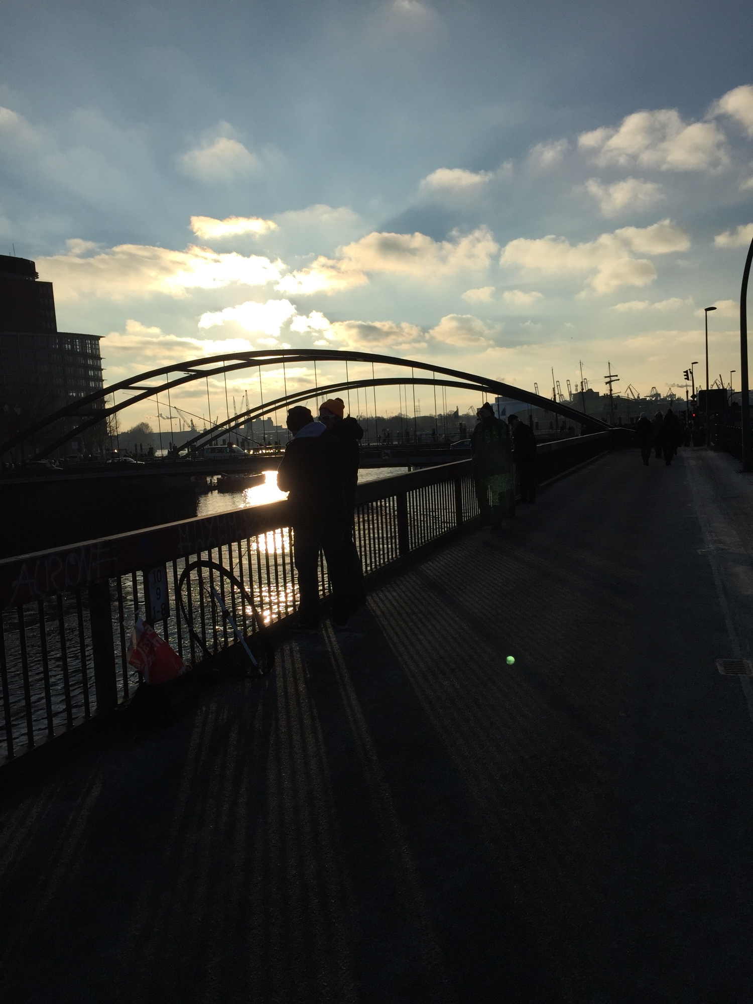 Angler an der Hafenpromenade in Hamburg, im Gegenlicht der Mittagssonne als Silhouetten