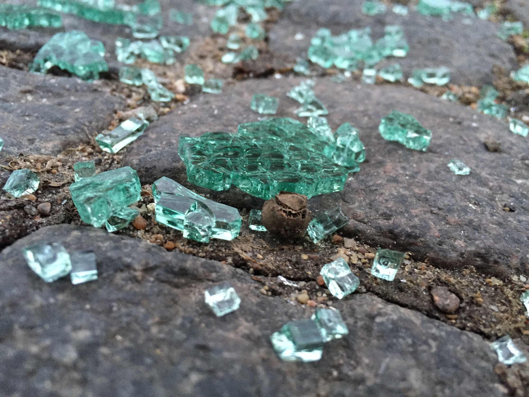 zerbrochenes Glas am Boden eines Parkplatzes