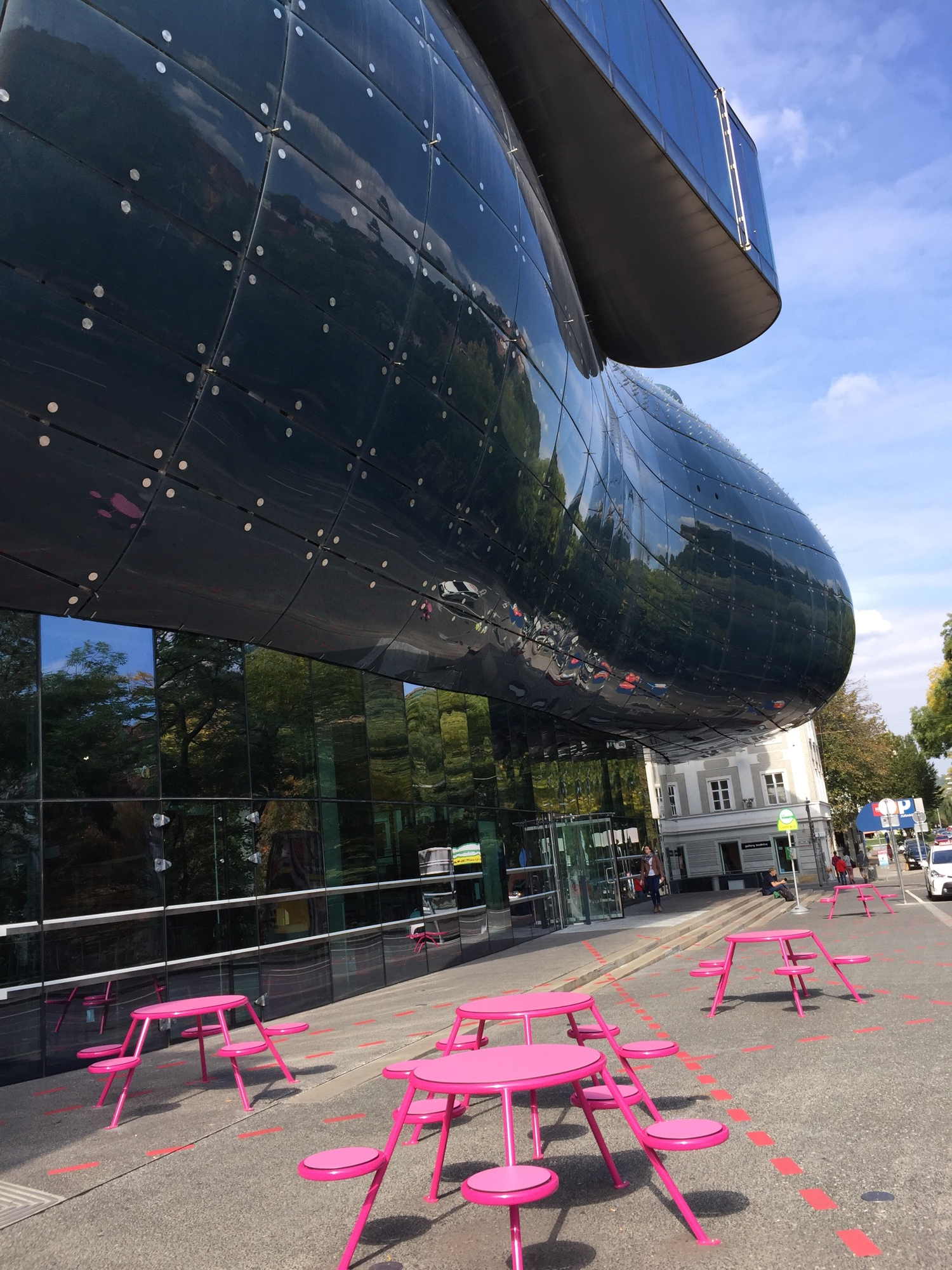 Friendly Alien mit rosafarbener Tisch-Hocker-Gruppe im Vordergrund