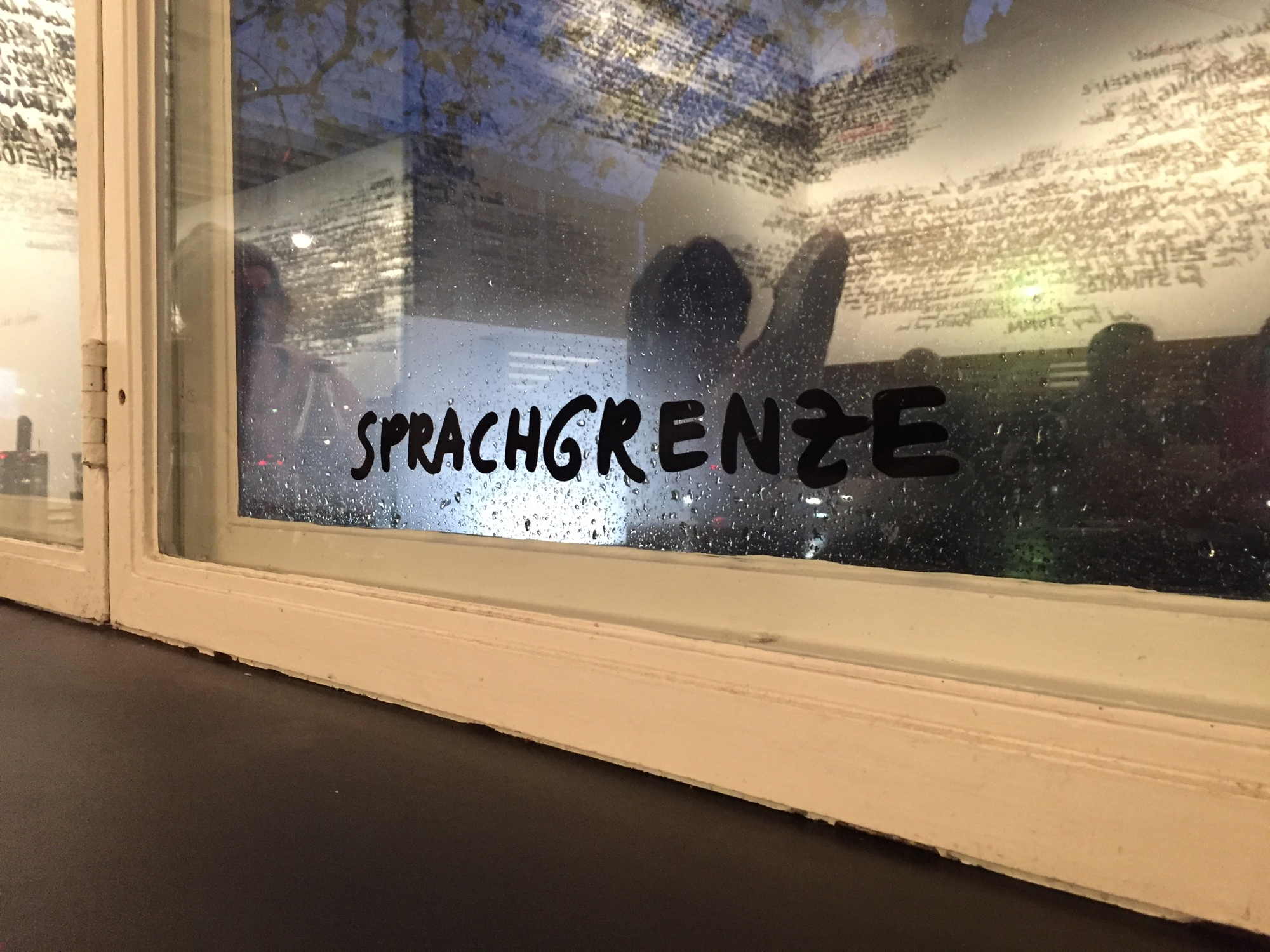 Schriftzug „Sprachgrenze“ am Fenster im Inneren des Kaffees im Amerika Haus | C/O Berlin