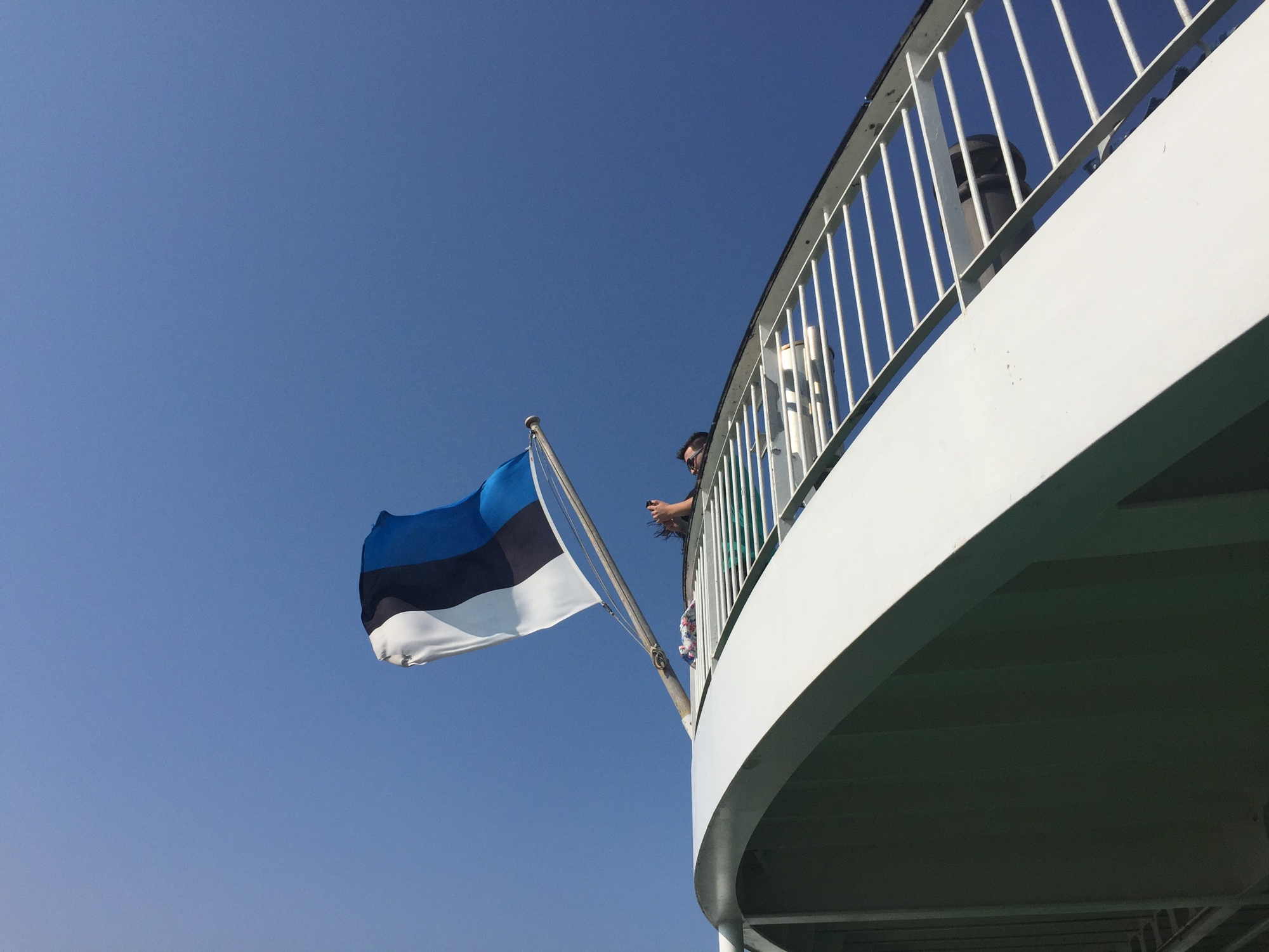 Blickrichtung vom unteren auf das obere Sonnendeck am hinteren Ende der Tallink Fähre, die estnische Flagge weht im Wind
