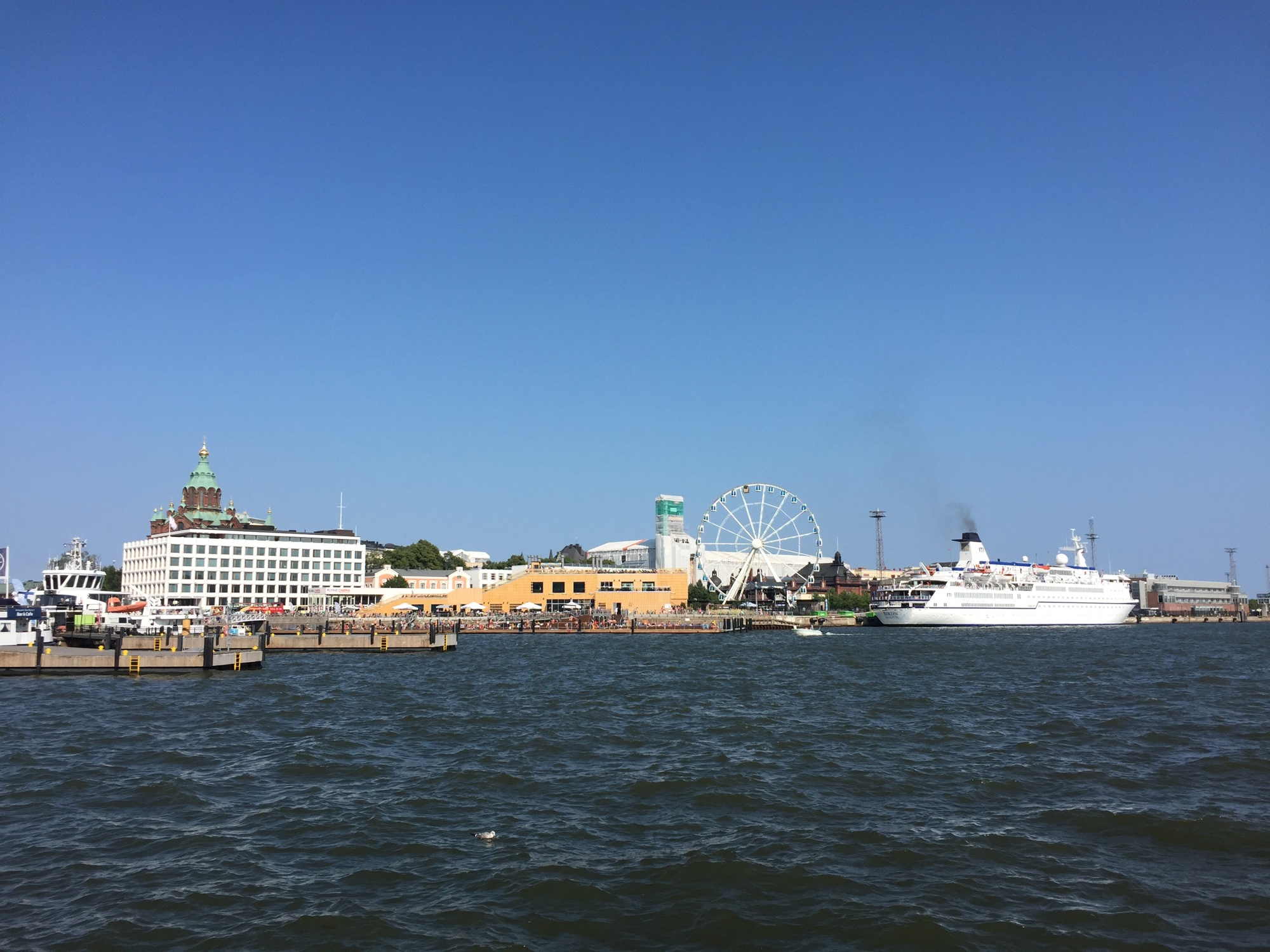 Aussicht auf die Hafenpromenade von Helsinki inklusive Riesenrad und Kreuzfahrtschiff