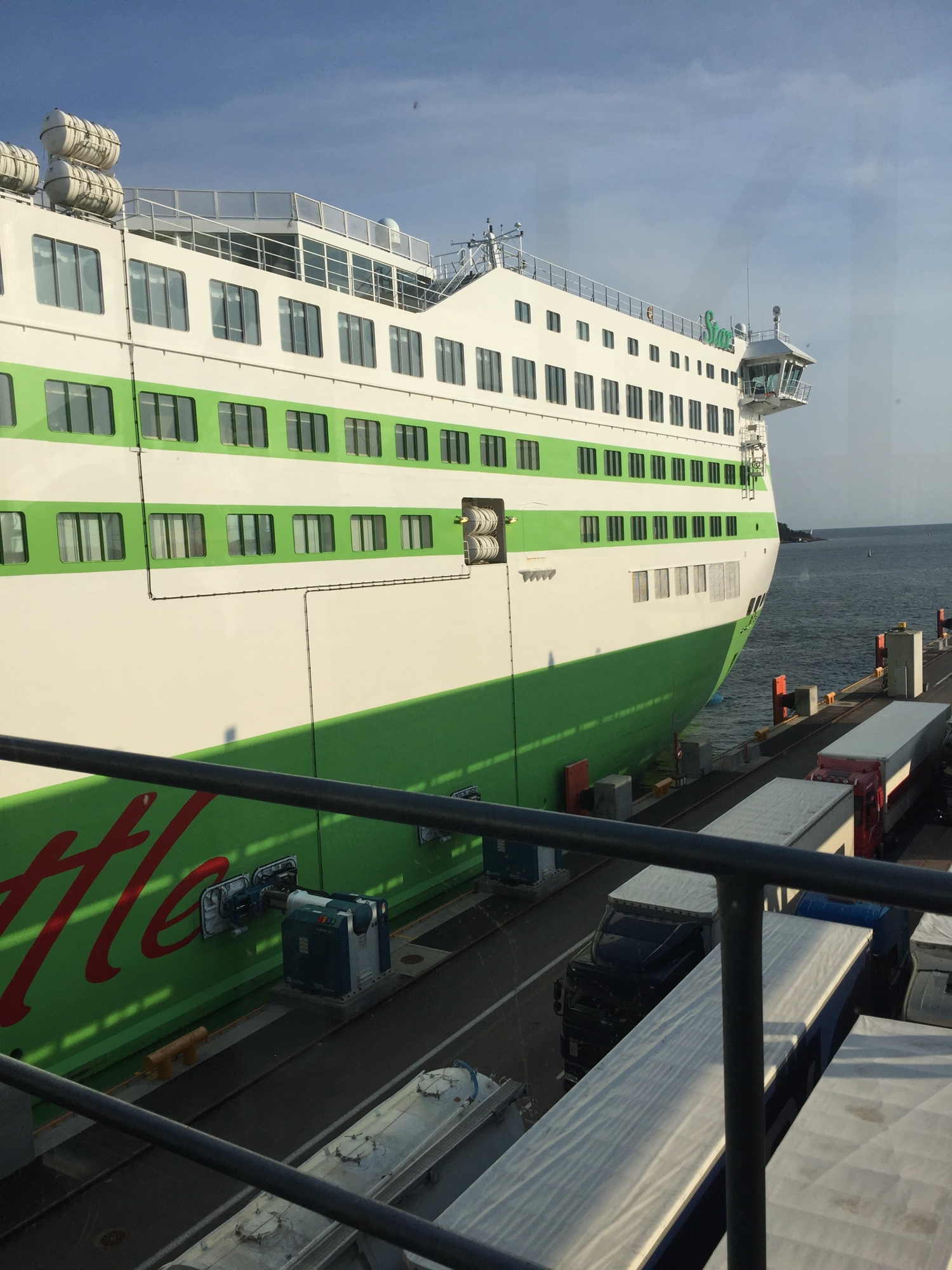 die Tallink-Fähre im Hafen von Helsinki, im Vordergrund zwei LKW-Schlangen, die auf das Verschiffen warten