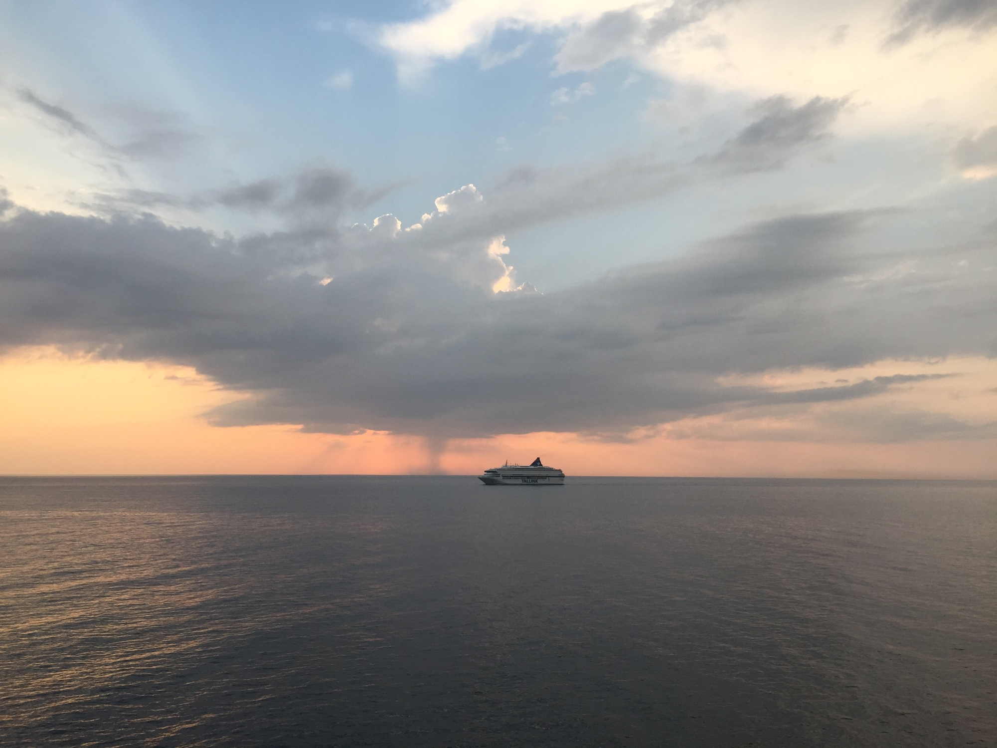 Blick aufs Meer, rosafarbener Sonnenuntergangshimmel mit dramatischen Wolken, ein weiteres Fährschiff am Horizont