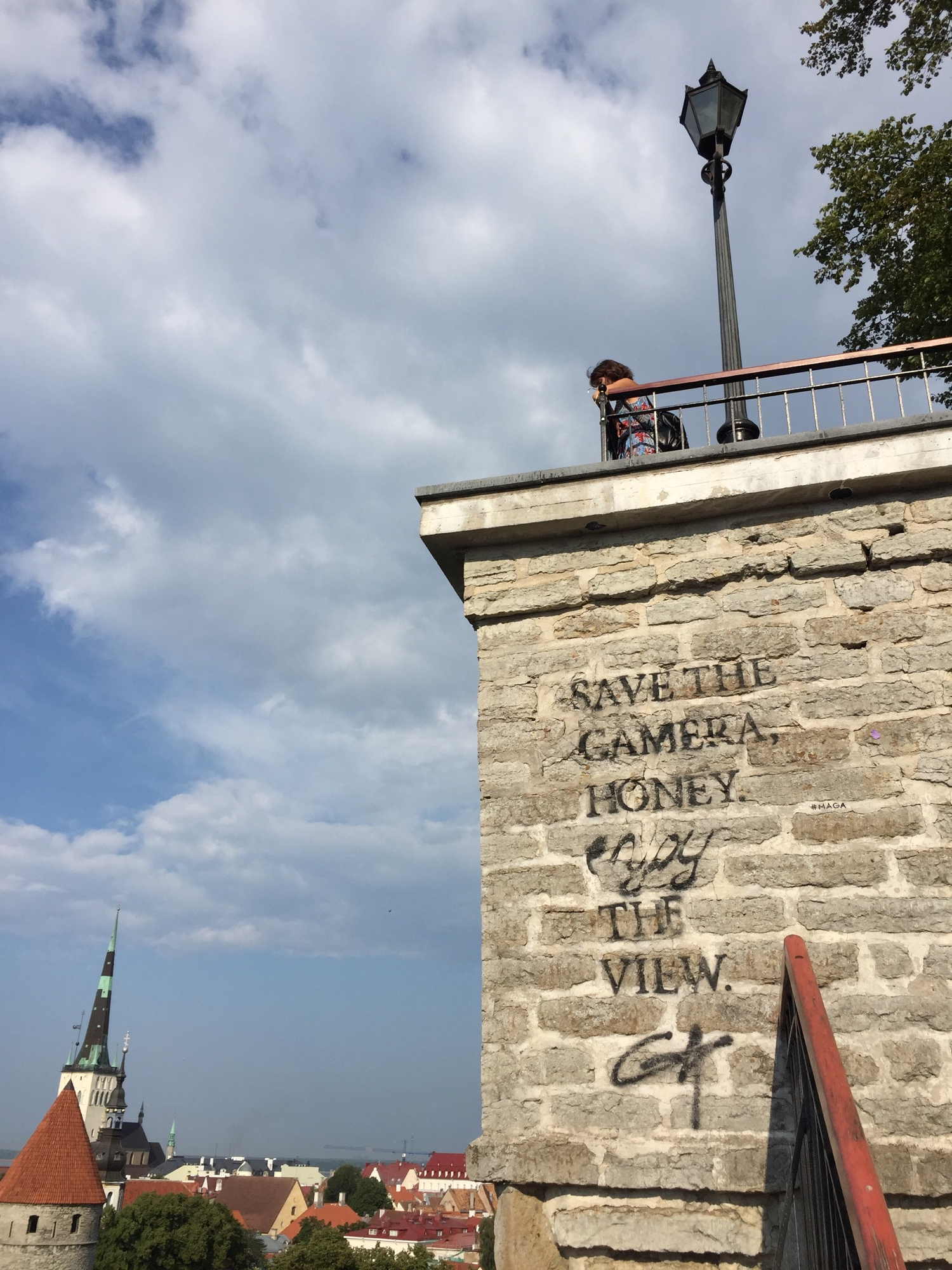 Aussichtsplattform auf den Befestigungsanlagen von Tallinn mit Ausblick auf die Innenstadt, an der Wand ein Graffitti: save the camera honey enjoy the view