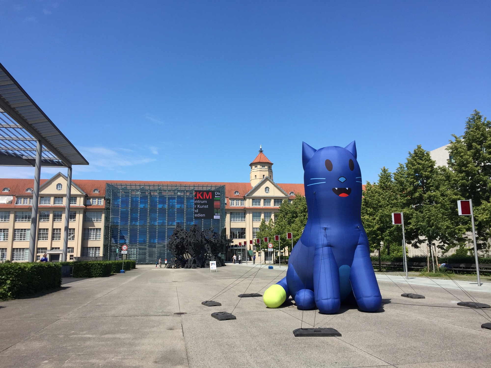 Blick auf das Zentrum für Kunst und Medien, im Vordergrund eine überlebensgroße aufgeblasene blaue Katze