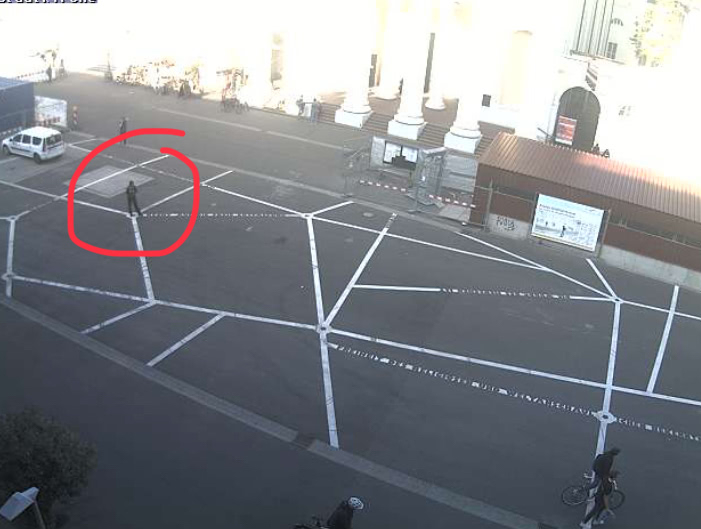 Screenshot vom Webcam-Blick auf den Marktplatz Karlsruhe, roter Kreis kennzeichnet die im Bild stehende Autorin