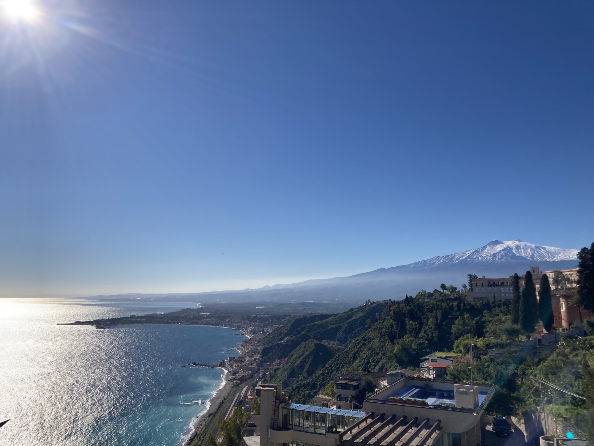 Aussicht nach dem Aufstieg nach Taormina, links Meer und Sonne, rechts im Hintergrund der schneebedeckte Gipfel des Ätnas