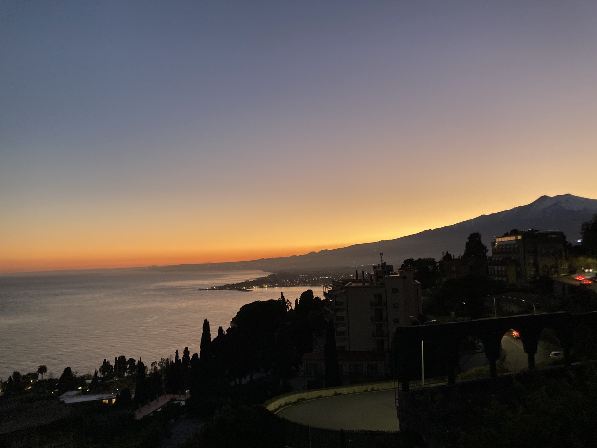 Sonnenuntergang an der sizilianischen Ostküste, rechts im Hintergrund der schneebedeckte Gipfel des Ätnas