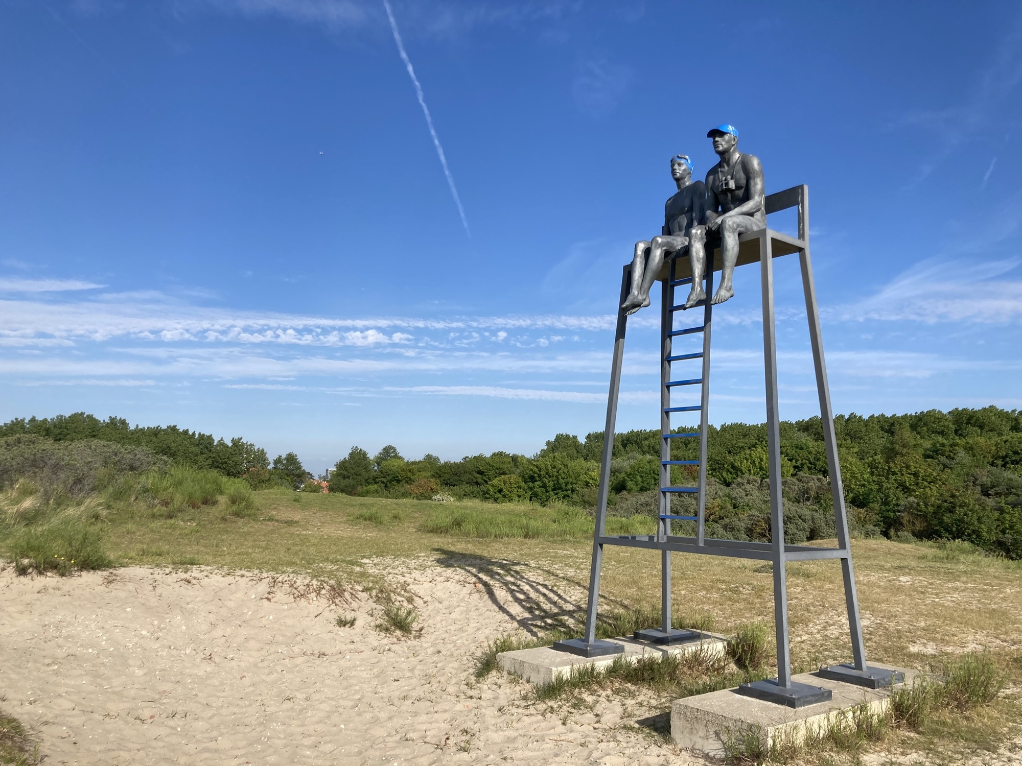 Skulptur zweier Personen, die auf einem Turm Richtung Strand schauen, sie stellen mutmaßlich Strand Security dar
