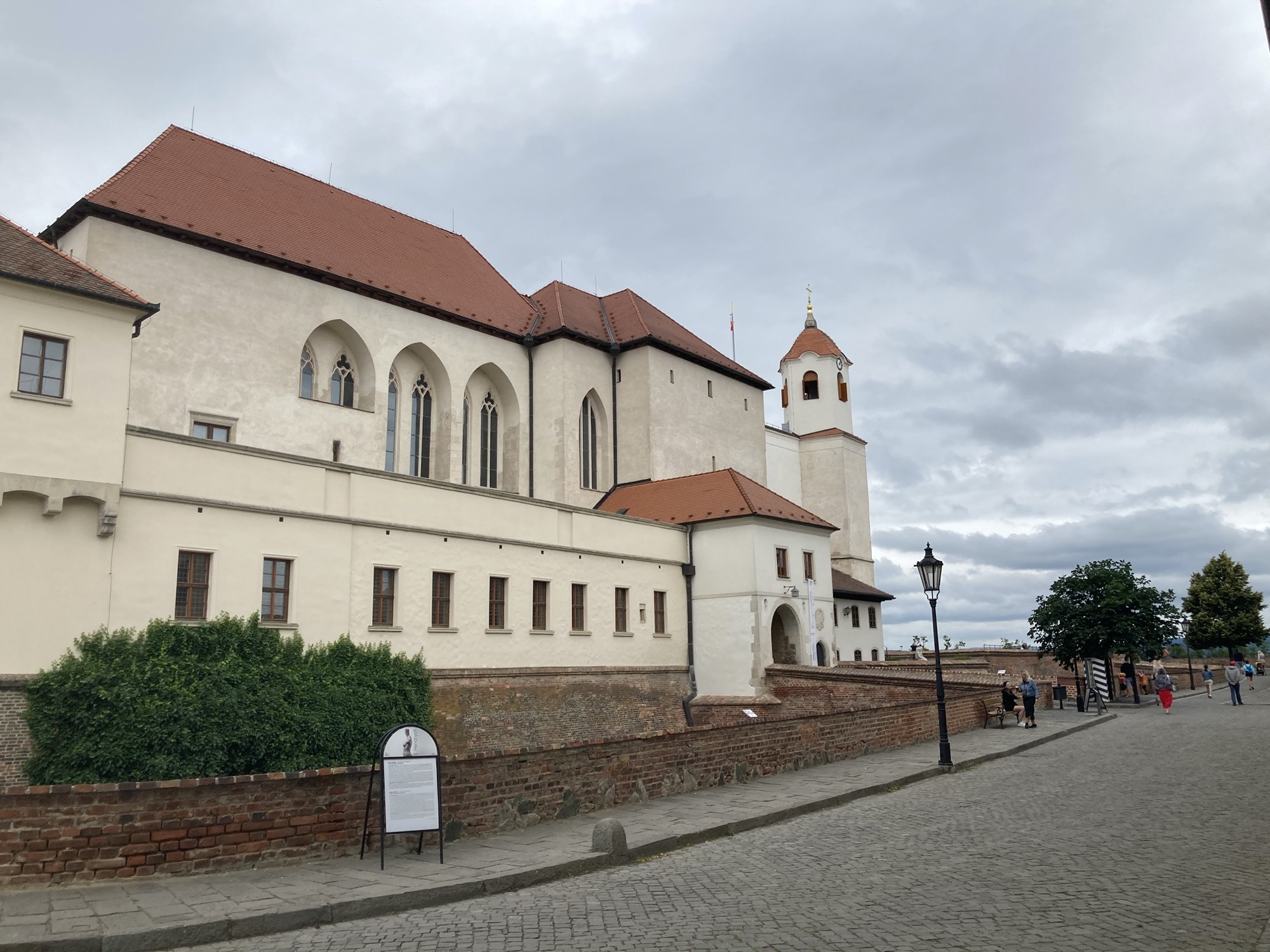 Festung Špilberk, ein hell gestrichenes Schloss mit einer Art Glockenturm vor bewölktem Himmel
