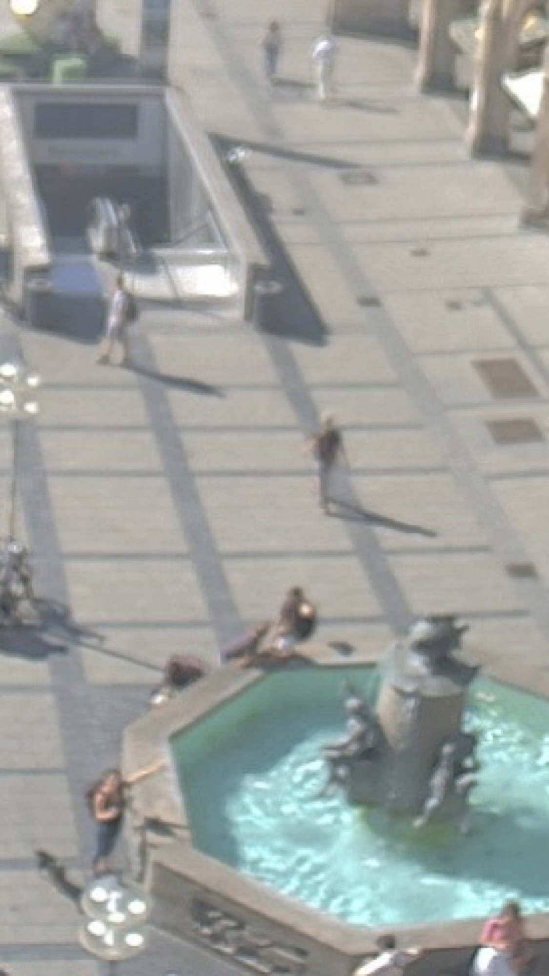 Screenshot der Webcam am Marienplatz, das Bild ist sehr verschwommen, rechts unten ist der Fischbrunnen zu sehen, am linken Rand des Brunnens steht eine Person, die auf den Fisch zeigt (das bin ich)