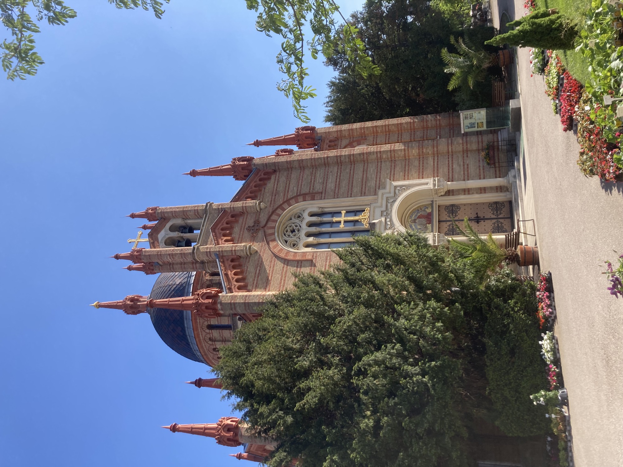 Frontansicht der protestantischen Kirche am Matzleinsdorfer Friedhof, es handelt sich um ein Ziegelgebäude in verschiedenen Rottönen mit einer Kuppel und vielen kleinen dekorativen Türmchen