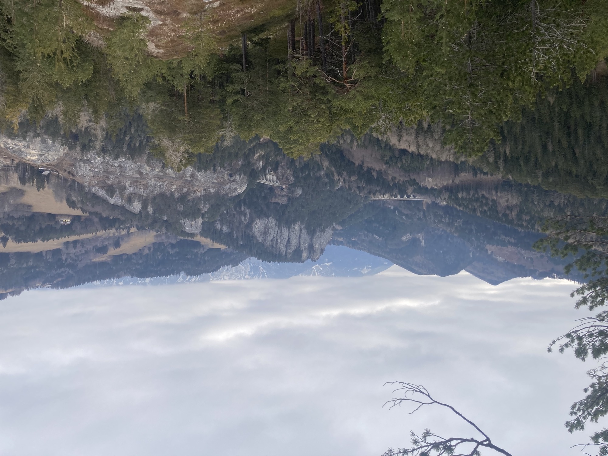 20-Schilling-Blick, Aussicht vom Berg auf eine Felsgruppe, die durch zwei Eisenbahnviadukte unterbrochen ist, die Berggipfel weiter im Hintergrund sind wolkenverhangen und nur zu erahnen